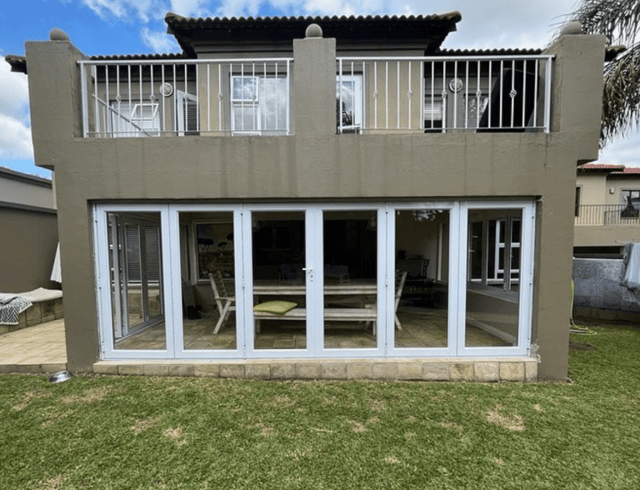 White aluminium folding doors opening a home's ground floor to the garden